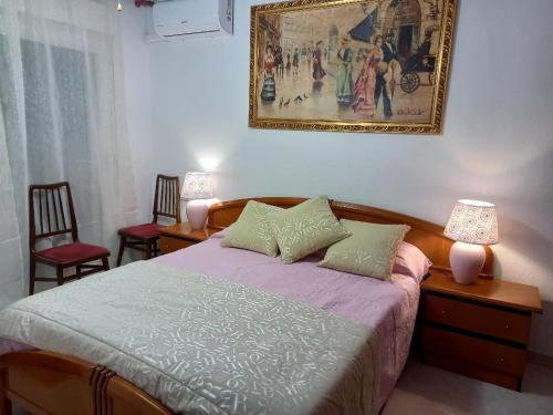 una camera da letto con un letto e un dipinto sul muro di Policarpo-centro a Torrevieja