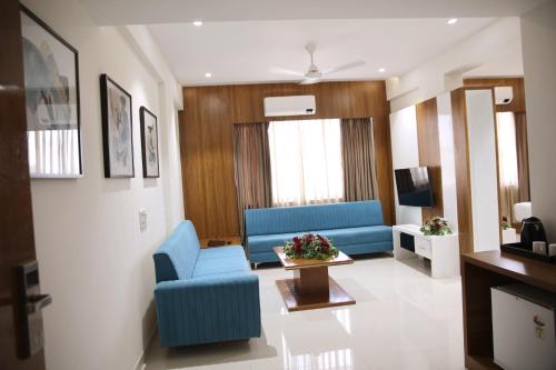 a living room with a blue couch and a table at Lords Eco Inn, Ambaji in Ambaji
