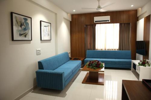 a living room with a blue couch and a table at Lords Eco Inn, Ambaji in Ambaji