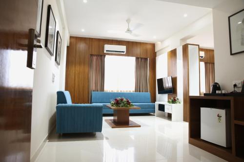 a living room with blue chairs and a couch at Lords Eco Inn, Ambaji in Ambaji