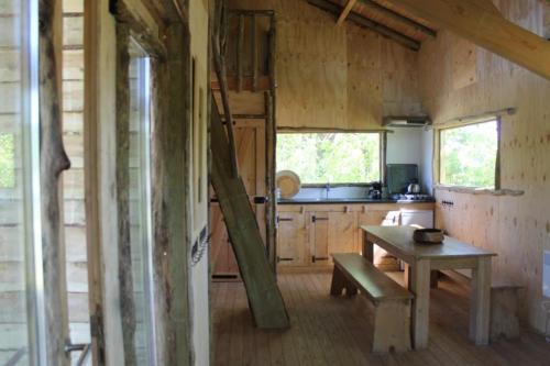 um quarto com uma mesa e uma escada numa cabina em Boomhut em Voorthuizen
