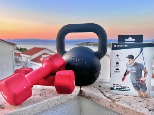a black and red kettlebell sitting on a counter next to a box at Attico "NIDO" a 50m dal mare con terrazzo grande - un'oasi di pace e bellezza in Nečujam