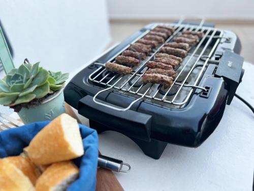 a grill with hamburgers cooking on it on a counter at Attico "NIDO" a 50m dal mare con terrazzo grande - un'oasi di pace e bellezza in Nečujam