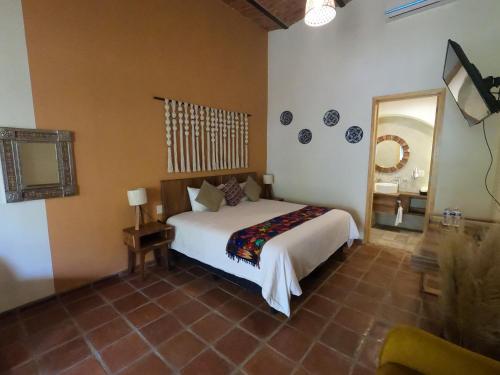 - une chambre avec un lit blanc et un miroir dans l'établissement Hotel Boutique Sol y Luna SPA, à Ajijic