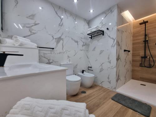a bathroom with two toilets and a marble wall at Villa de lujo con piscina climatizada in Mogán