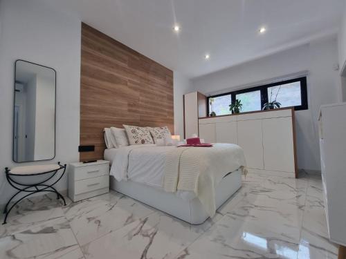 モガンにあるVilla de lujo con piscina climatizadaのベッドルーム(大型ベッド1台、鏡付)
