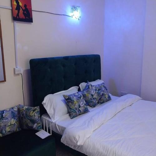ein Schlafzimmer mit einem Bett mit Kissen darauf in der Unterkunft Aura's Airbnb in Busia