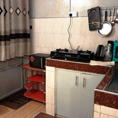 eine Küche mit einem Herd und einer Arbeitsplatte in der Unterkunft Aura's Airbnb in Busia