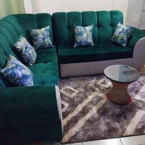 ein grünes Sofa und einen Tisch im Wohnzimmer in der Unterkunft Aura's Airbnb in Busia
