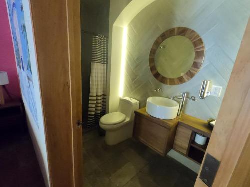 a bathroom with a toilet and a sink and a mirror at Hotel Boutique Sol y Luna SPA in Ajijic
