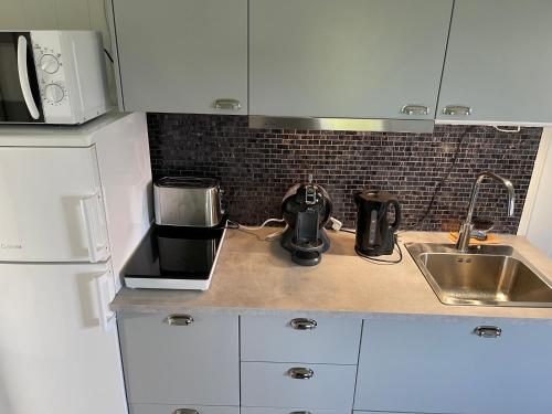 a kitchen counter with a sink and a coffee maker at Cottage Sanna in Jönköping