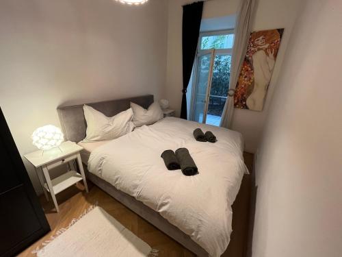 1 dormitorio con 1 cama con 2 zapatillas en Apartment with garden - central station, en Viena