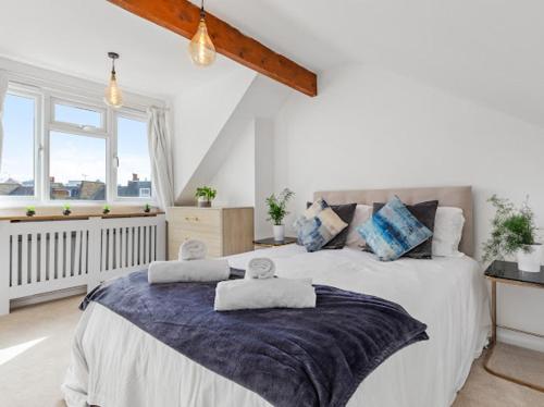 una camera da letto con un grande letto con asciugamani di Chelsea Maisonette a Londra