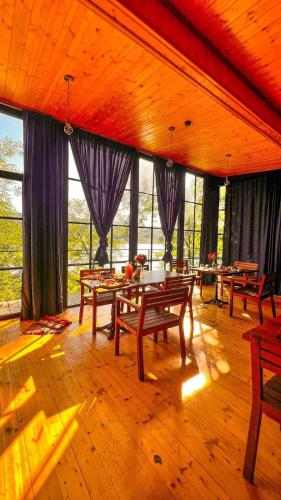 a large room with tables and chairs and windows at Porto Gumati in Kutaisi