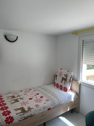 a small bed in a room with a window at Manaslu home in Palaiseau