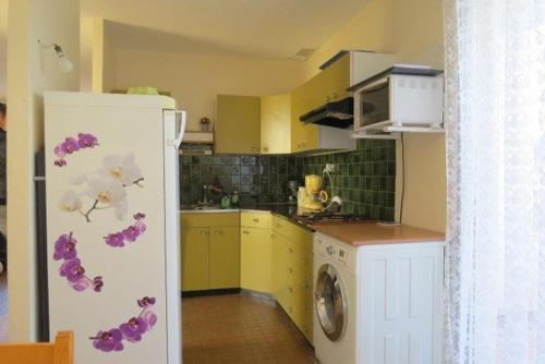 Il comprend une cuisine avec un réfrigérateur et des fleurs. dans l'établissement Agréable Maison Familiale 100 m de la plage 6AVAN5, au Barcarès