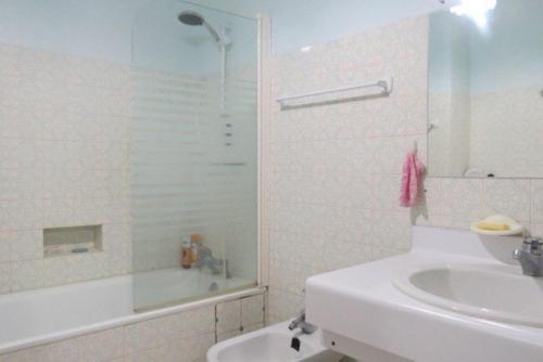 une salle de bain blanche avec un lavabo et une douche dans l'établissement Agréable Maison Familiale 100 m de la plage 6AVAN5, au Barcarès