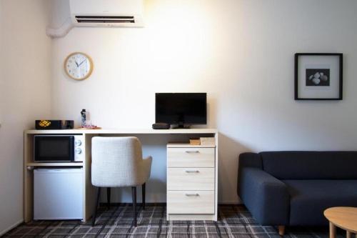 a living room with a desk with a microwave and a blue couch at Sweet Stay Kyoto - Vacation STAY 21712v in Kyoto