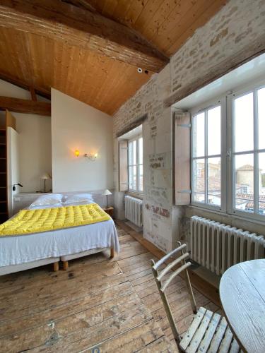 a bedroom with a bed and a wooden ceiling at Hôtel Le Sénéchal in Ars-en-Ré
