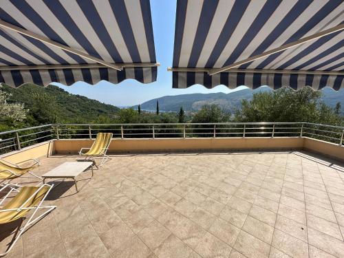 eine Terrasse mit 2 Stühlen und 2 Sonnenschirmen in der Unterkunft Apartman Sofija HN in Herceg-Novi