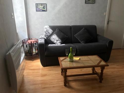 ein Wohnzimmer mit einem schwarzen Sofa und einem Couchtisch in der Unterkunft Appartement silencieux avec une belle vue . in Morez