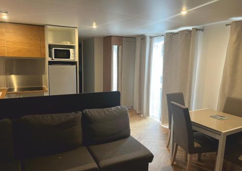 聖布勒萬雷潘的住宿－Grand mobile-home 45M2 au calme et au bord de mer，客厅配有沙发和桌子