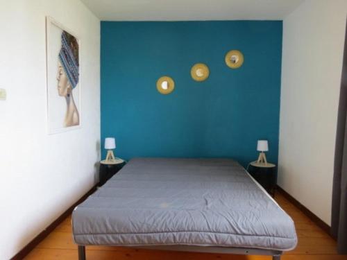 - une chambre dotée d'un lit avec un mur bleu dans l'établissement Villa familiale piscine privée 6 personnes 6BJ21, à Saint-Estève