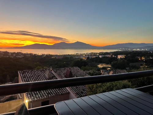 vistas a la puesta de sol desde el balcón de un edificio en Studio Vue Mer - Piscine - Porticcio, en Porticcio