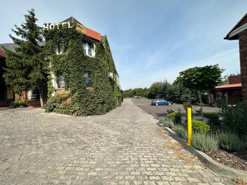 a building covered in ivy on a street at Hotel Kresowianka in Konin