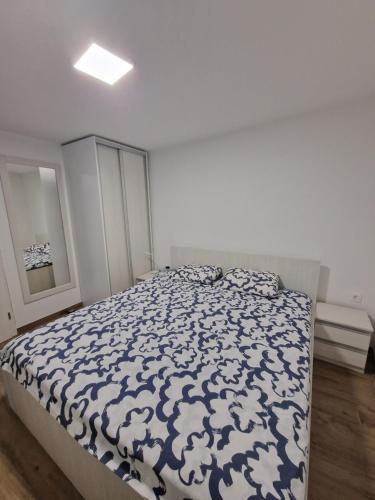 a bedroom with a bed with a blue and white comforter at Apartma Sinitus in Izola