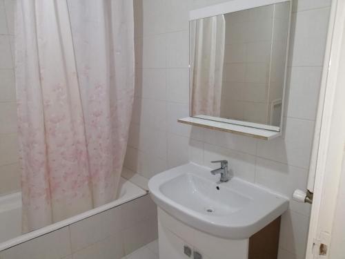 a white bathroom with a sink and a shower at Ahlem palmeraies résidence in La Marsa