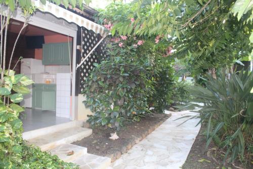 a garden entrance to a house with a plant at Gite bagatelle classé 2 étoiles in Sainte-Rose