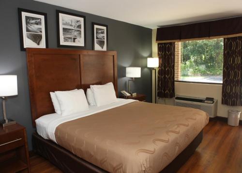 um quarto de hotel com uma cama grande e uma janela em Quality Inn Kenly I-95 em Kenly