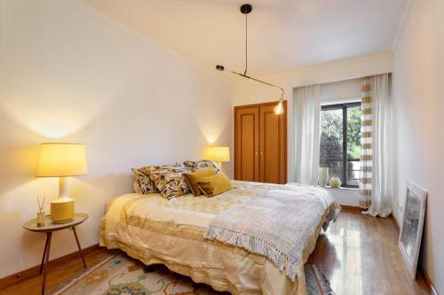 a bedroom with a bed and two lamps and a window at Oporto, sea view and marina in Canidelo