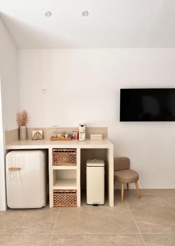 un bureau blanc avec une chaise et une télévision sur un mur dans l'établissement Le Clos des Délices - Love Room - Chambre avec spa, terrasse et parking privatif, à Aubagne
