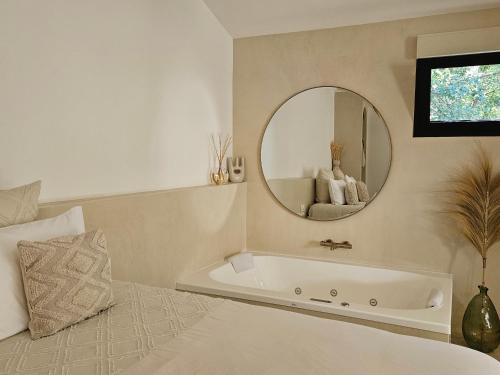 a bath tub in a bedroom with a mirror at Le Clos des Délices - Love Room in Aubagne