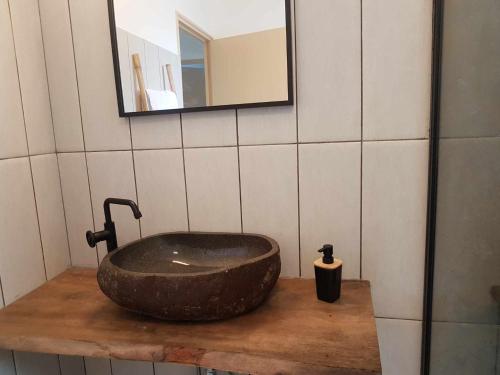 uma casa de banho com um lavatório de pedra e um espelho. em VILLA TI COIN FRAIS em La Plaine des Palmistes