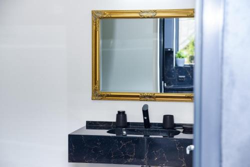 bagno con specchio e lavandino nero di Anna Chalet a Breaza de Sus