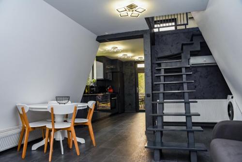 a dining room with a table and chairs and a spiral staircase at Anna Chalet in Breaza de Sus