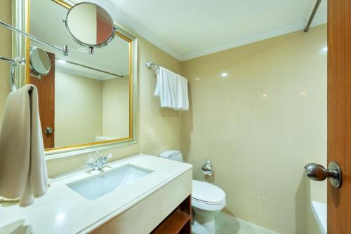 a bathroom with a sink and a toilet and a mirror at Nasa Bangkok in Bangkok