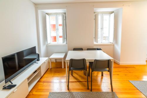 a dining room with a white table and chairs at Golden Place - Cacilhas in Almada