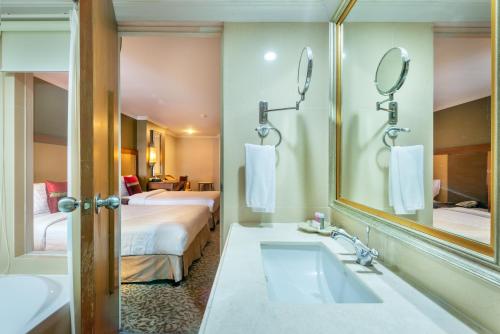 a bathroom with a sink and a large mirror at Nasa Bangkok in Bangkok