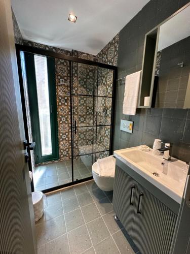 a bathroom with a shower and a sink and a toilet at Esmahan Forest and Pool by Zehra Suites in Marmaris