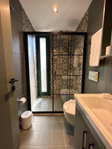 y baño con ducha, aseo y lavamanos. en Esmahan Forest and Pool by Zehra Suites, en Marmaris