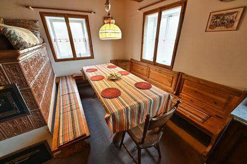 a dining room with a table and two windows at Chalupa u kostela pro 9 in Chřibská