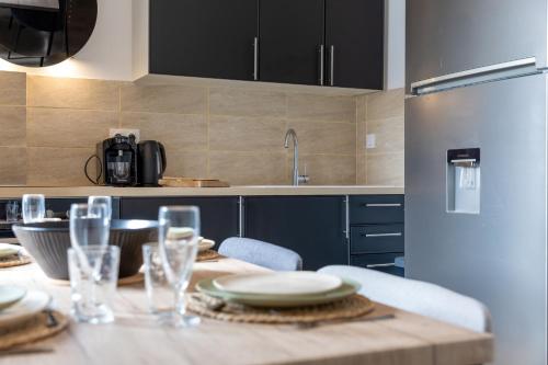 a kitchen with a table with plates and glasses on it at ZenBNB - Évasion - Colocation - Ch 39 - Proche Transport in Annemasse