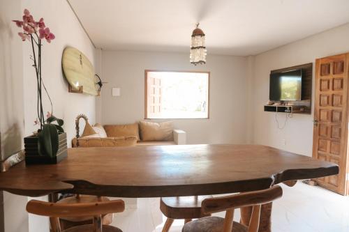 a dining room with a wooden table and chairs at Vila hangloose Jericoacoara in Acaraú