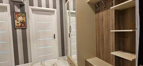 a walk in closet with a white door and shelves at Park Azure Comfortable Apartment in Baku