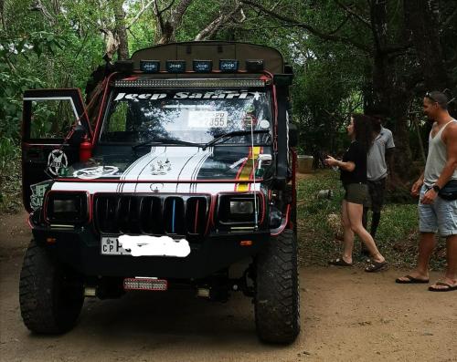 a jeep parked on a dirt road with people standing around at Hotel Bird Paradise in Sigiriya