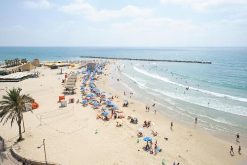 a group of people on a beach with umbrellas at Residence Beach Hotel in Netanya